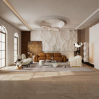 A modern, sunlit living room featuring a warm brown leather sofa, cream accent chairs, a marble coffee table, and a textured beige wall backdrop, with light wood flooring and large arched windows.