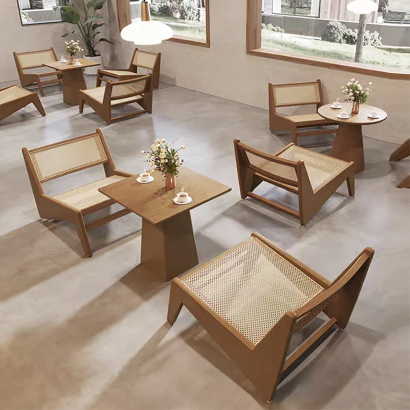 Modern wooden furniture set with chairs and tables in a room with large windows.