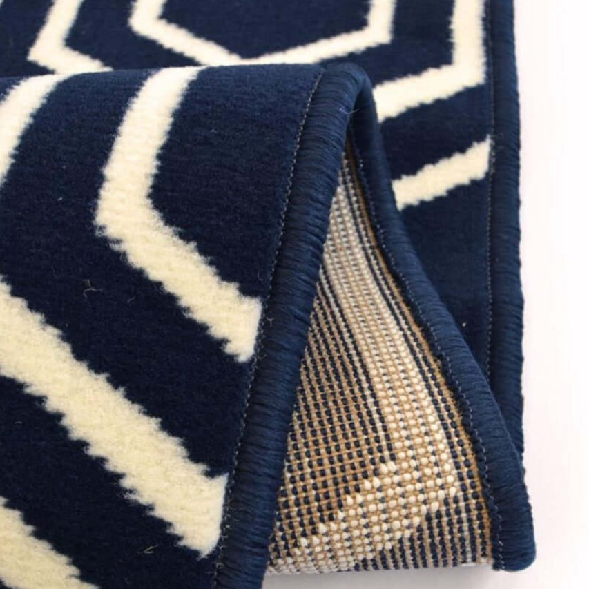 Navy blue and white geometric patterned rug with a textured back on a white background