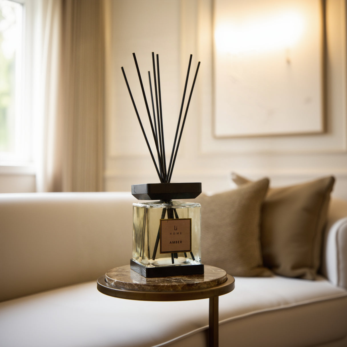Diffuser with black sticks on a marble table in a living room setting