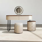 Dressing table with round mirror, stool, and side table on a neutral background