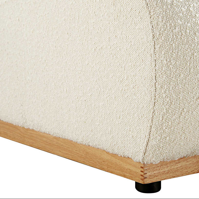 Close-up of a textured white sofa with wooden legs on a white background