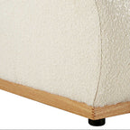 Close-up of a textured white sofa with wooden legs on a white background