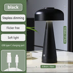 Black table lamp with USB charging cable on a neutral background