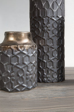Two decorative vases with intricate patterns on a wooden surface.
