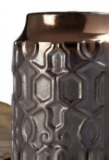 Decorative vase with metallic finish and geometric pattern on a white background