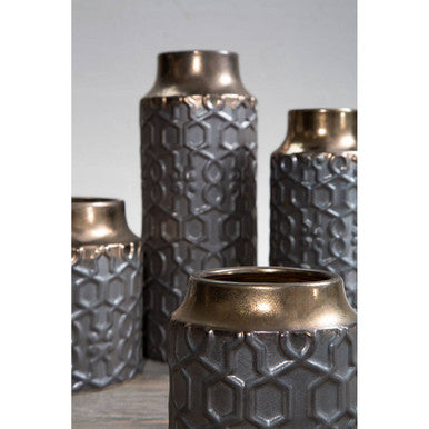 Set of metallic vases with honeycomb pattern on a neutral background