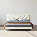 Modern bed with tufted headboard and wooden accents on a plain background