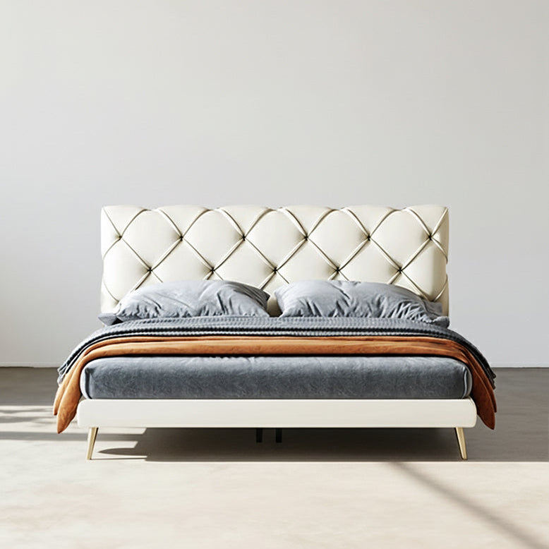 Modern bed with tufted headboard and wooden accents on a plain background