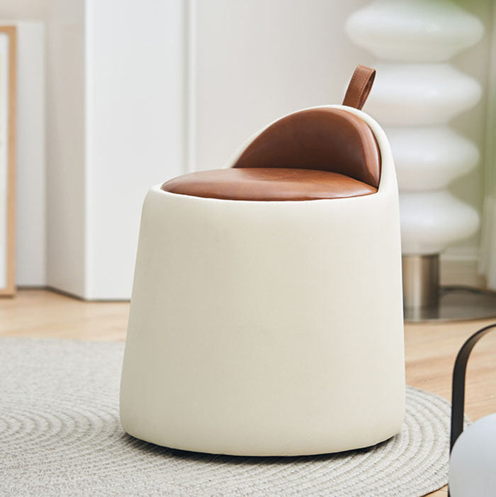 White and brown ottoman in a room with a rug and chair.