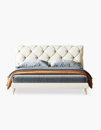 Modern bed with tufted headboard and gray bedding on a white background