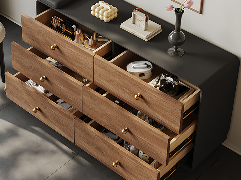 Wooden dresser with open drawers containing various items on a dark surface.
