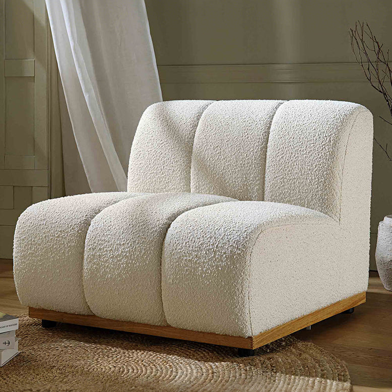 White textured armchair in a room with curtains and a rug.