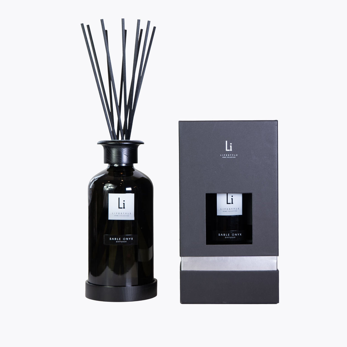 Black diffuser bottle with reeds and packaging on a white background