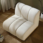 White plush armchair in a room with a plant and curtains