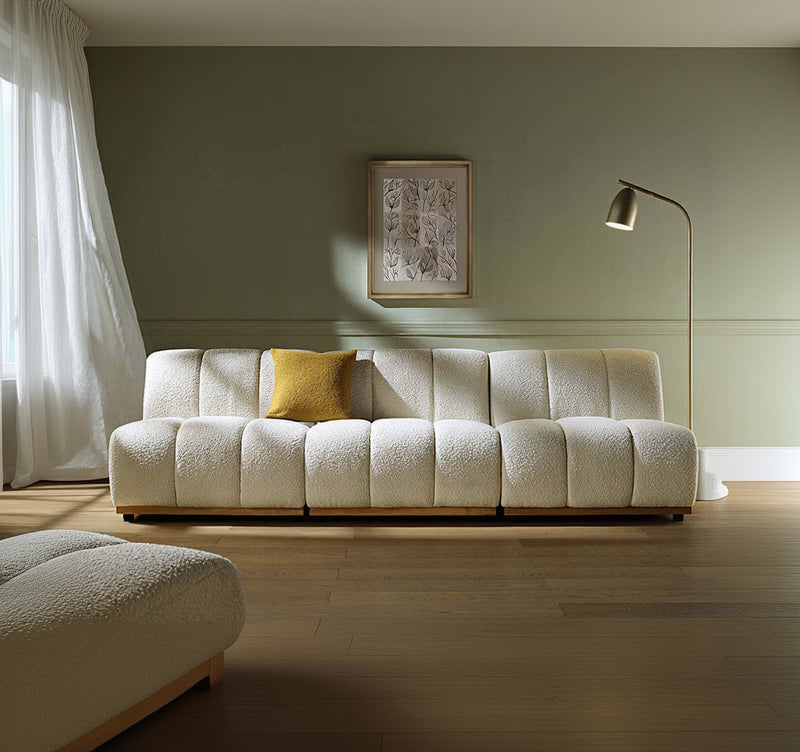White textured sofa with a yellow pillow in a room with a lamp and framed picture on the wall.