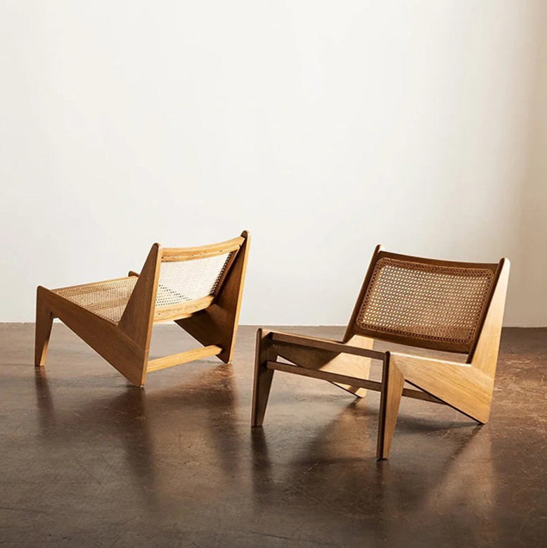 Two wooden chairs with woven backrests on a plain floor.