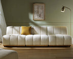 White textured sofa with a yellow pillow in a room with a lamp and framed picture on the wall.
