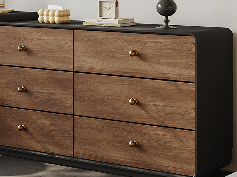 Wooden dresser with black accents and gold knobs on a neutral background