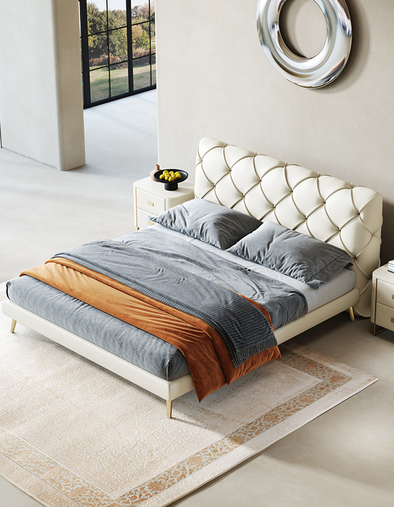 Modern bedroom with a tufted bed and decorative pillows.