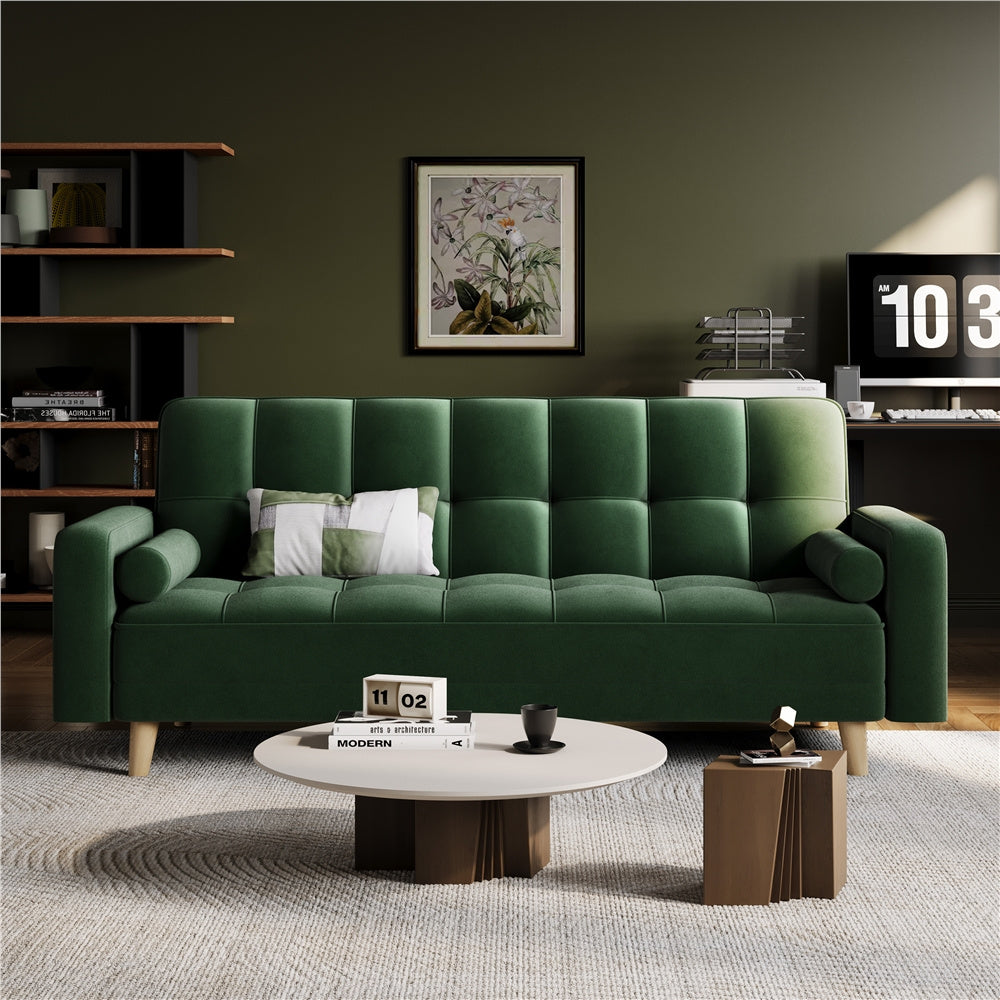 Green sofa in a living room with a coffee table and decorative items.