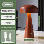 Brown table lamp with USB charging port on a wooden surface, featuring text on its benefits.