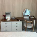 Small vanity with mirror, chair, and various items against a wooden wall.