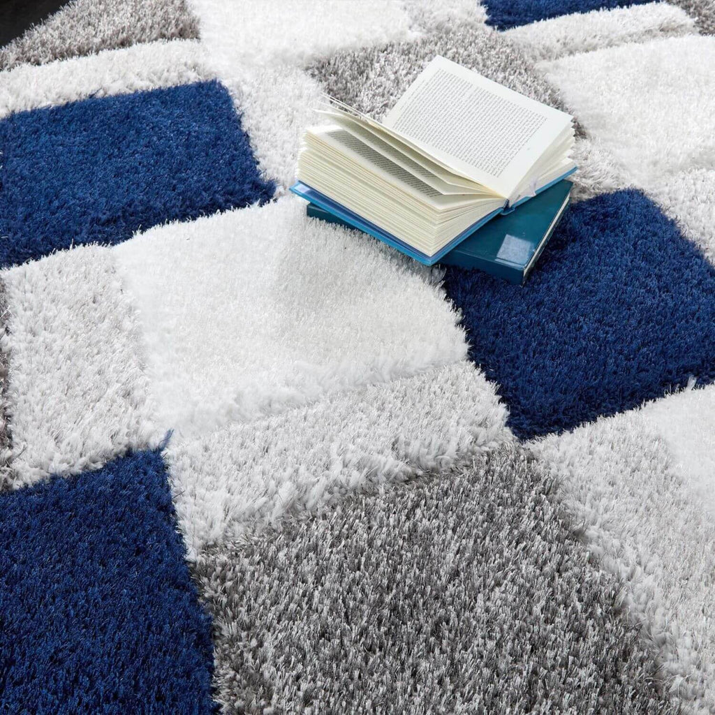 Open book on a geometric-patterned rug with blue, white, and gray colors.