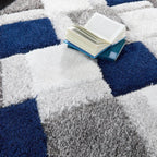 Open book on a geometric-patterned rug with blue, white, and gray colors.
