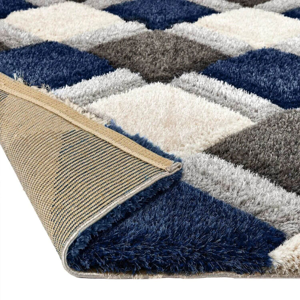 Close-up of a textured rug with geometric pattern in blue, gray, and beige.