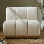 White textured armchair in a room with a plant and books on a shelf.