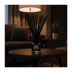 Black diffuser on a table in a dimly lit room with a lamp and plant in the background