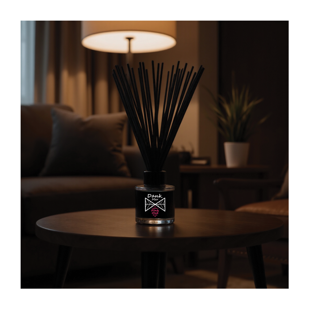 Black diffuser on a table in a dimly lit room with a lamp and plant in the background