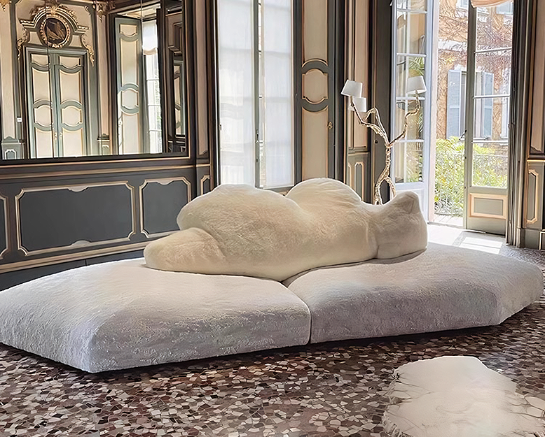 Modern cloud-shaped sofa in an elegant room with large windows.