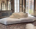 Modern cloud-shaped sofa in an elegant room with large windows.
