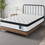 White mattress on a wooden bed frame with a black metal headboard in a room setting.