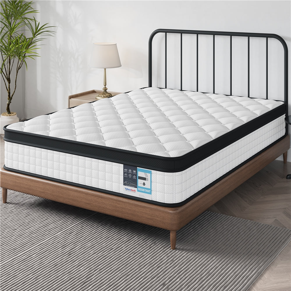 White mattress on a wooden bed frame with a black metal headboard in a room setting.