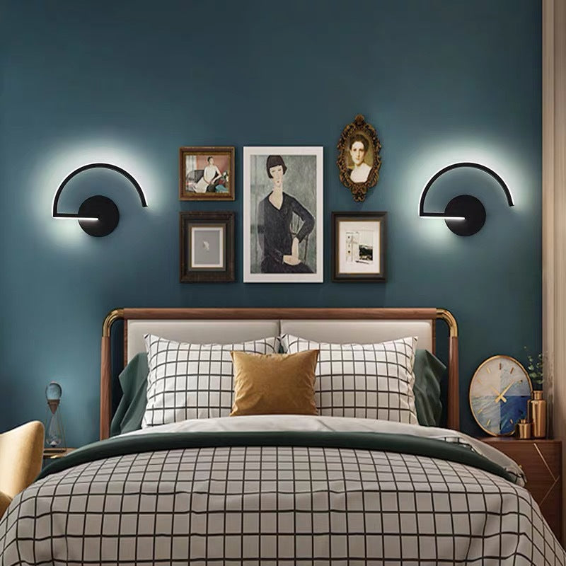 Bedroom with dark blue walls, framed pictures, and modern wall lights.