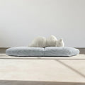 Modern gray sofa with a white cushion on a neutral background
