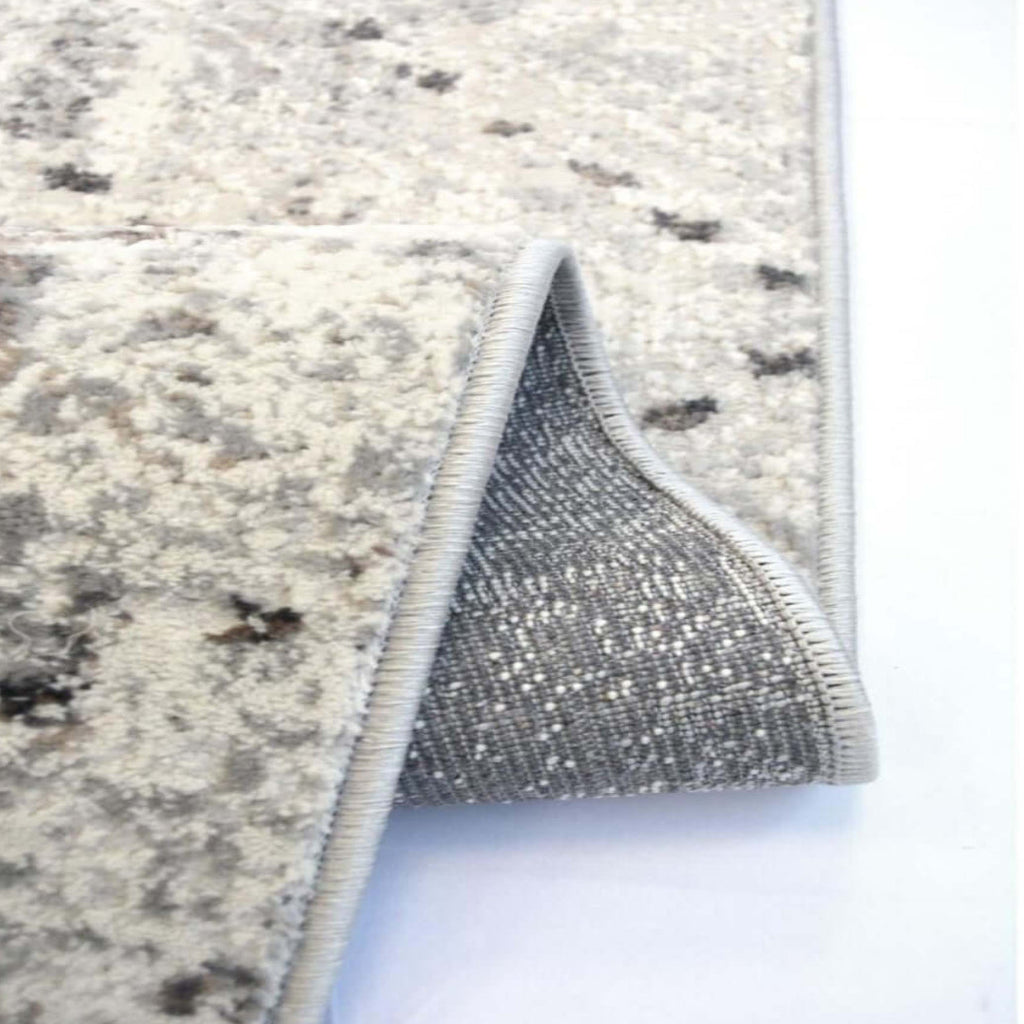 Close-up of a textured rug with a metallic border on a white background