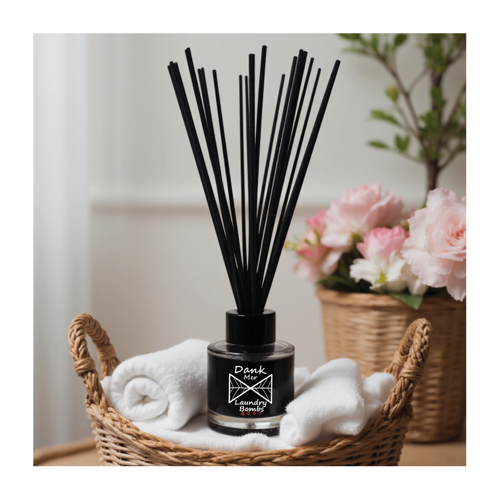 Diffuser with black sticks in a wicker basket with white cloths and flowers in the background