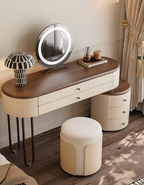 Dressing table with illuminated mirror, drawers, and a stool in a room setting.