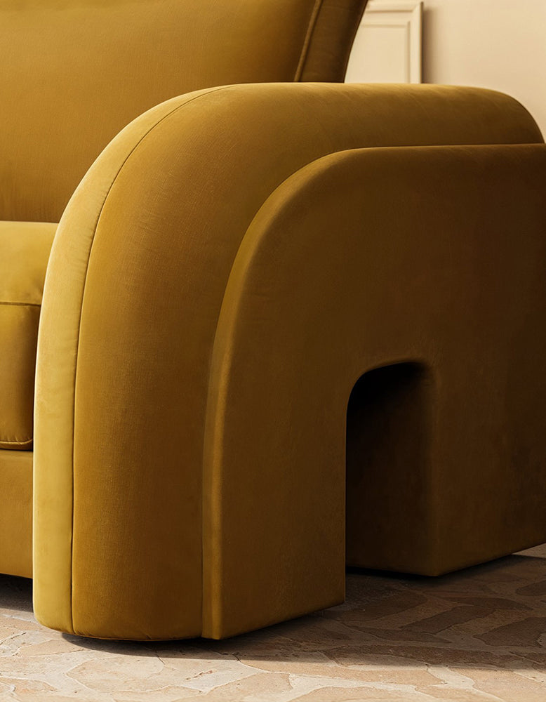 Close-up of a mustard yellow armchair with a soft texture.