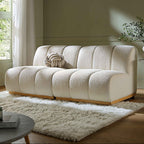 Beige sofa in a living room with a green wall and window.