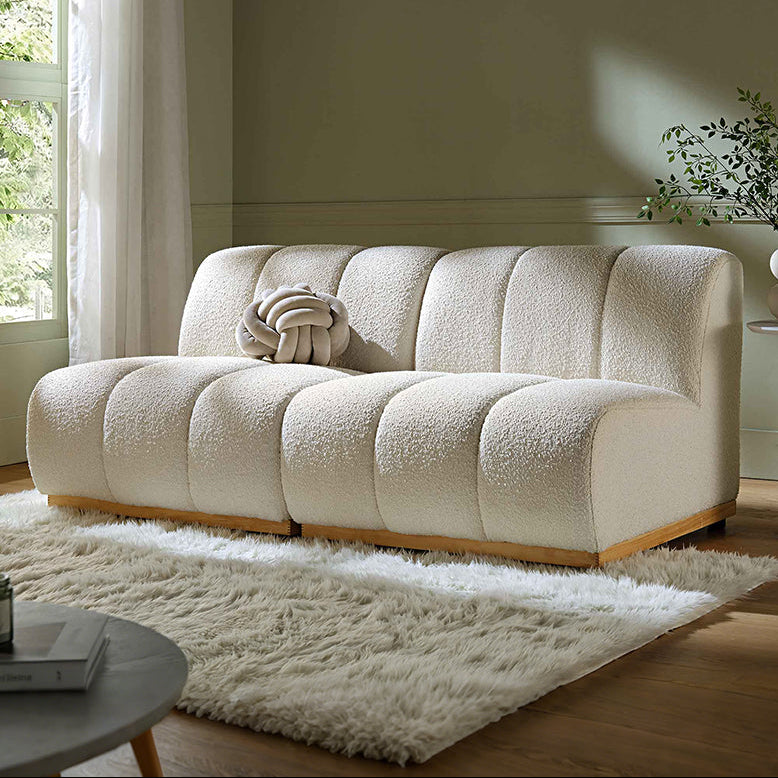 Beige sofa in a living room with a green wall and window.