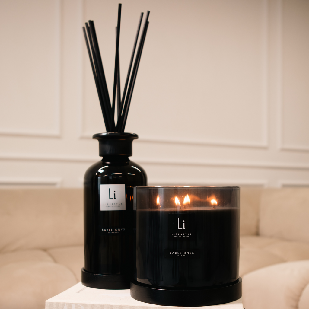 Black candle and diffuser with 'Li' branding on a table.