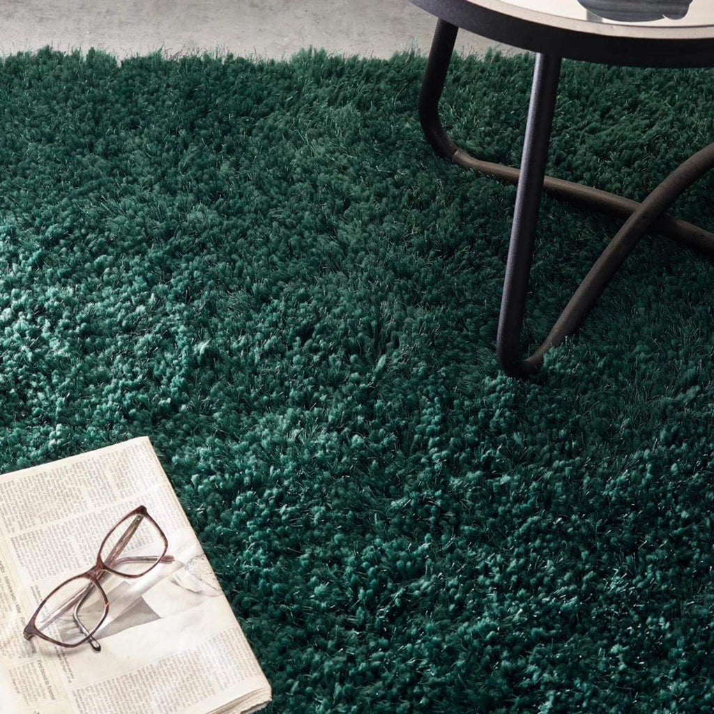 Green shaggy rug with a table and newspaper on it