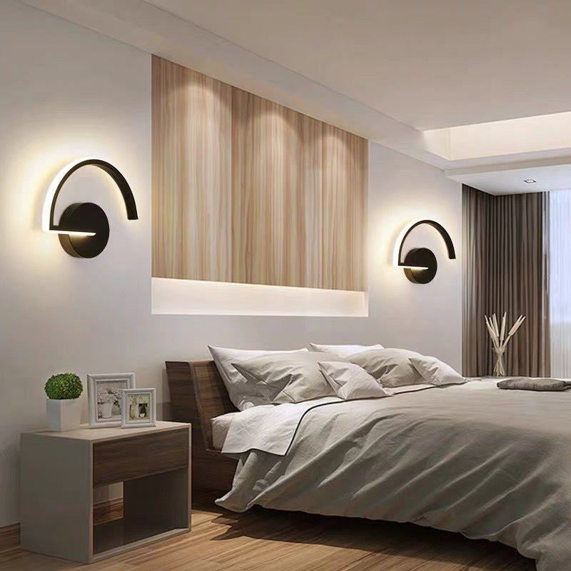 Modern bedroom with a bed, nightstands, and wall lights.