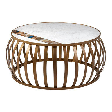 Round coffee table with marble top and metallic gold base on a white background