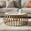 Round wooden coffee table with a vase and books in a living room setting.